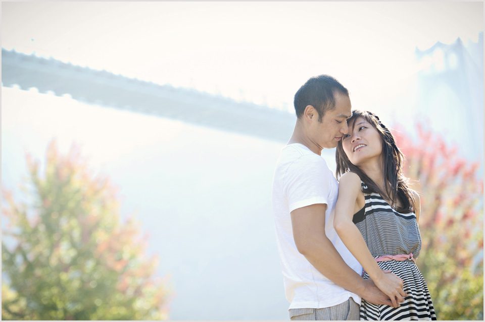 girl looks at fiancé with St. John's bridge in the background