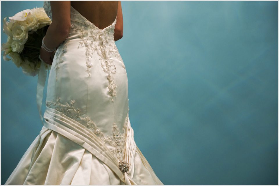 back of brides dress against a turquoise wall