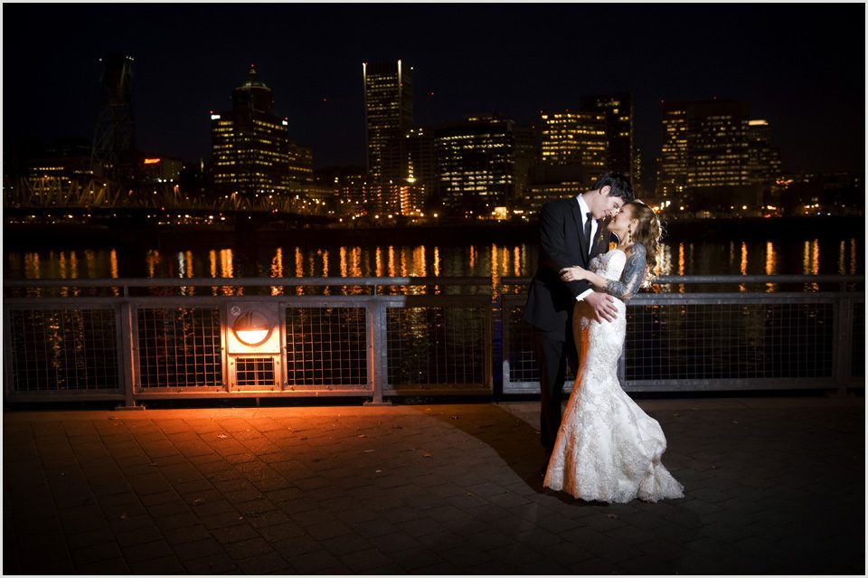 bride and groom at night with the Portland city skyline in the background